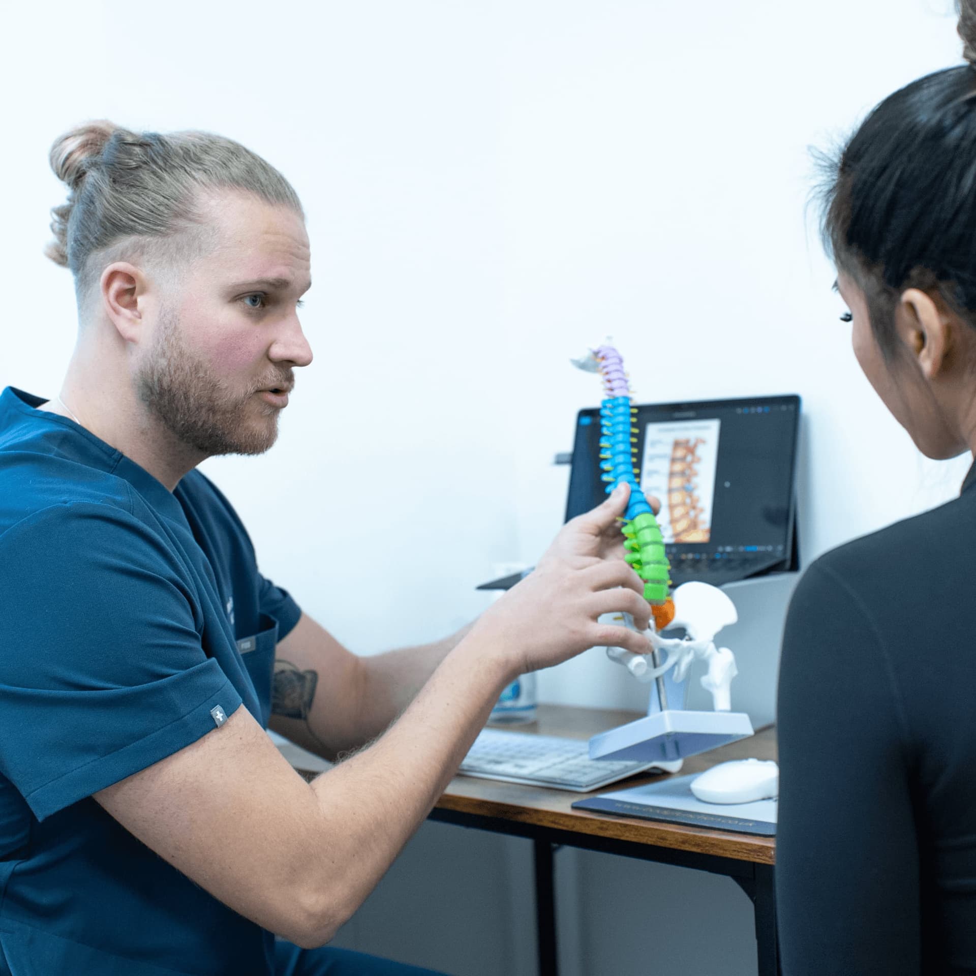 Side view of posture screening consultation at an osteopathy and physiotherapy clinic