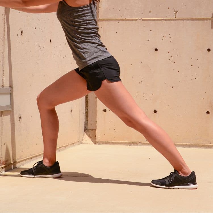 Standing calf stretch against a wall, back leg straight and heel down