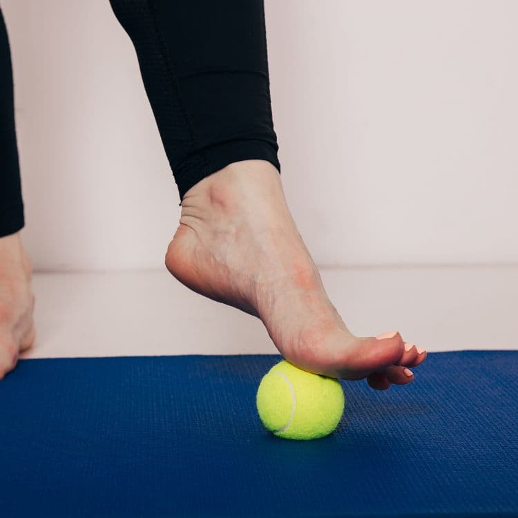 Rolling the sole of the foot over a ball